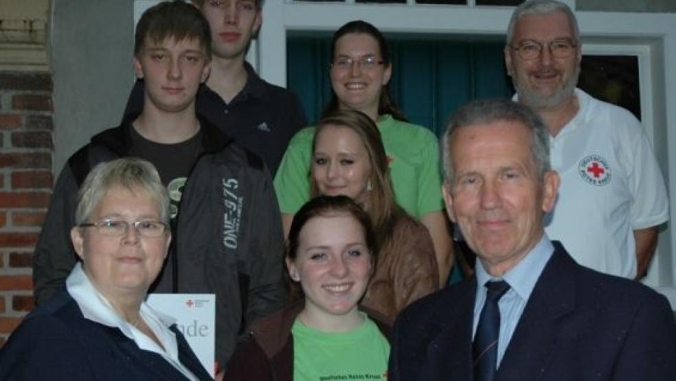 Gruppenbild nach der Ehrung: Rheiderland-DRK-Vorsitzender Dr. Dieter Babbel, rechts, Vorstandsmitglied Hildegard Hinderks, links, Bereitschaftsleiter Hermann Pott, hinten rechts, und Jugendrotkreuzleiterin Elke Rose, hinten Mitte, mit den Geehrten Bianka Smidt, Maren Duhm, Jens Frikke und Heiko Kuper.  © Foto: Pastoor