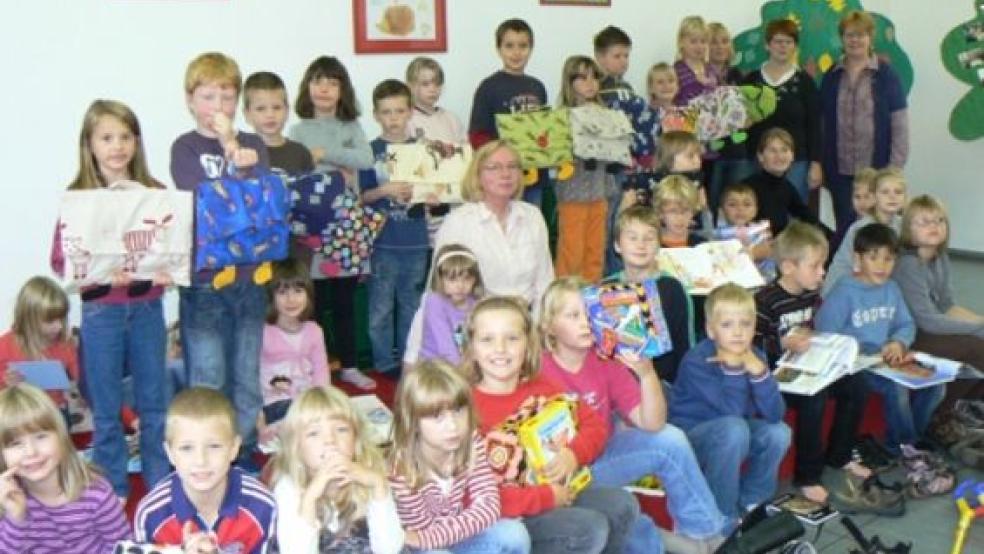 Am liebsten hätten es sich die Kinder ja länger auf dem Podest gemütlich gemacht, aber nach dem Foto scheuchten die Lehrer die Schüler der Grundschule Stapelmoor wieder in die Klassenräume. Die Vertreterinnen des Fördervereins (rechts) durften noch bleiben, denn als Dankeschön für die Spende gab es von Büchereimitarbeiterin Anita Timmer (Mitte) noch Kaffee und Kuchen.  © Foto: Himstedt