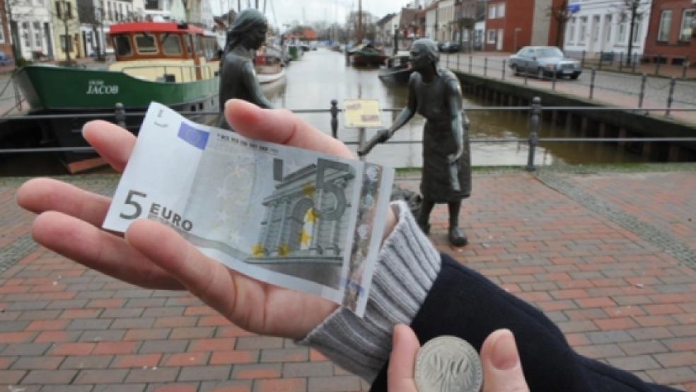 Fünf-Euro-Schein versus Fünf-Markstück (Sonderprägung) am Alten Hafen in Weener: Vor zehn Jahren löste der Euro die Deutsche Mark ab. Im Rheiderland teilen sich die Meinungen - die einen wünschen die Mark zurück, die anderen sehen im Euro Vorteile. © 