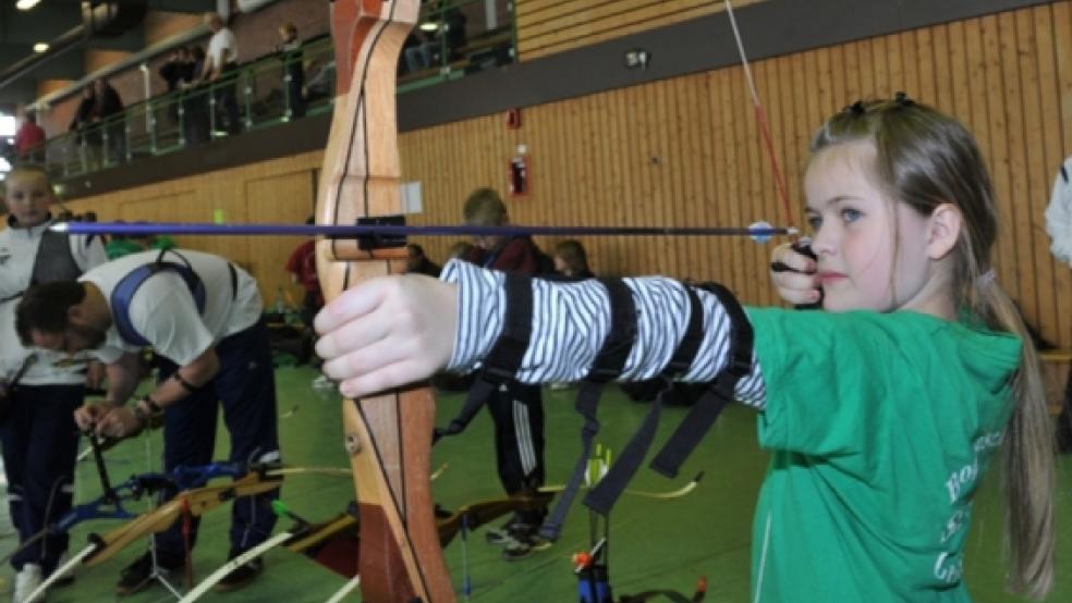 Etliche Pfeile fliegen am Sonnabend wieder in der Turnhalle der Phönixschule. Hier visiert die achtjährige Melanie aus Victorbur mit ihrem Bogen die Scheibe an. Sie war eine unter den fast 80 Sportlern, die im vergangenen Jahr beim Neujahrsschießen dabei waren.  © Archiv-Foto: Bruins