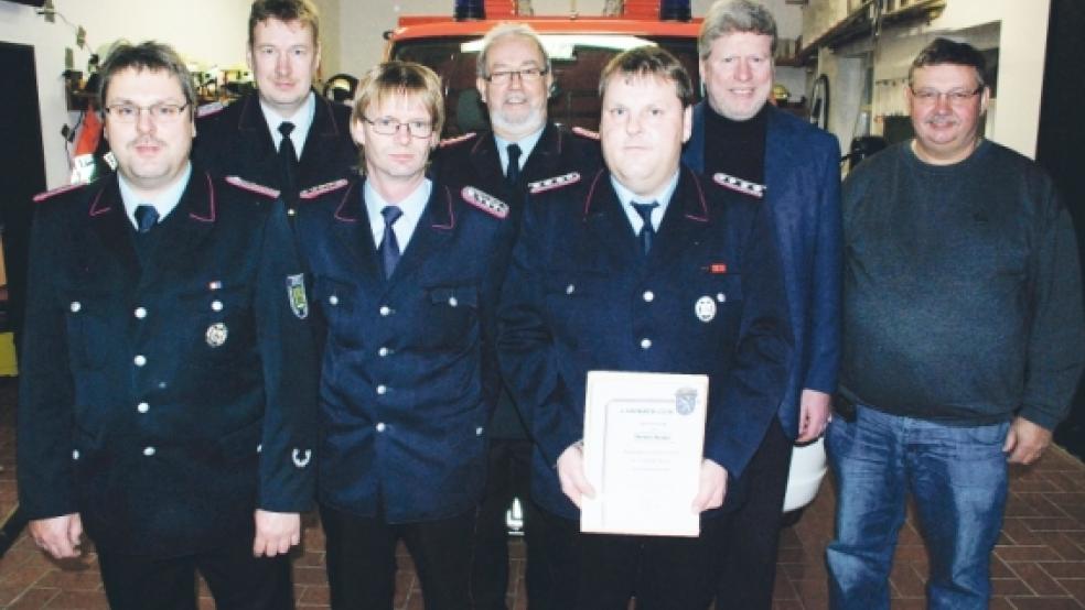 Geehrt und wiedergewählt: Für 25jährige Dienste im Feuerlöschwesen wurde Dietmar Kuiper (auf dem Foto mit Urkunde) geehrt. Als Ortsbrandmeister wiedergewählt wurde Gert Kuiper (vorne links), zwischen beiden steht Hartmut Sap (stellvertretender Ortsbrandmeister). Dahinter (von links) Ernst Berends (Kreisfeuerwehr), Gemeindebrandmeister Friedrich Schmidt, Bürgermeister Johann Tempel und Ratsherr Günter Harms (Feuerschutzausschussvorsitzender). © Fotos: Kuper