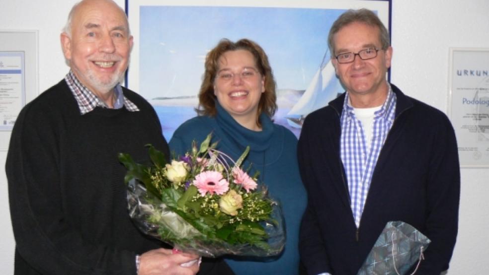 Blumen für die neue Chorleiterin Anja Geber: Mit strahlenden Gesichtern begrüßten der bisherige Chorleiter Hans-Egon Düring (rechts) und Heinrich-Peter Snakenborg jetzt Anja Geber in den Reihen der Bunner Jungs. © Foto: Himstedt