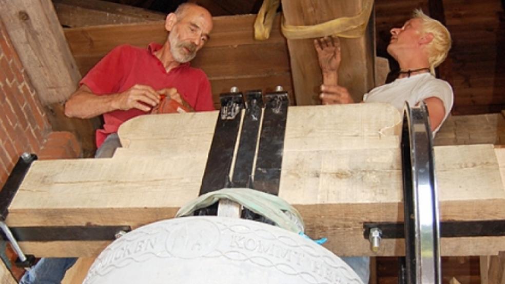 Jacobus Nibuur und Simon Laudy (rechts) montieren das Joch der 1180 Kilogramm schweren Christusglocke der Evangelisch-lutherischen Matthäikirche in Bingum. © Foto: A. Siegmund