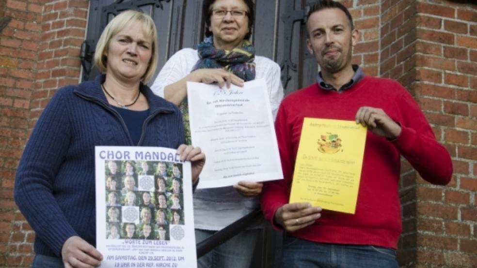 Die Festwoche in »Verlaat« beginnt am kommenden Sonntag. Die Plakate dazu präsentieren die Kirchenratsmitglieder (von links) Angelika Wilken, Karin Mertens und André Woldendorp. © Wübbena