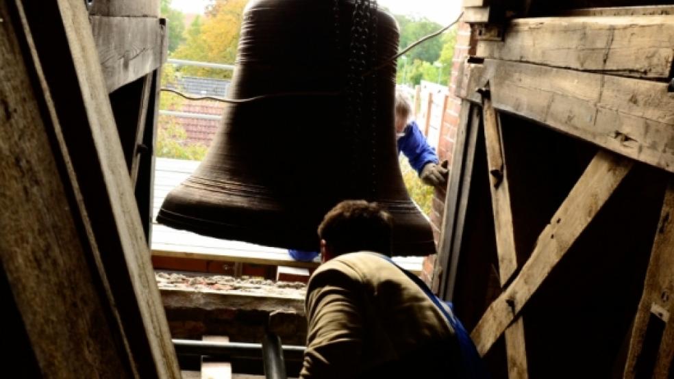 Akkurat gehen Michael Brieger (vorne) und Jürgen Eichenberger (hinter der Glocke) beim Einsetzen der restaurierten Glocke vor.  © Wübbena