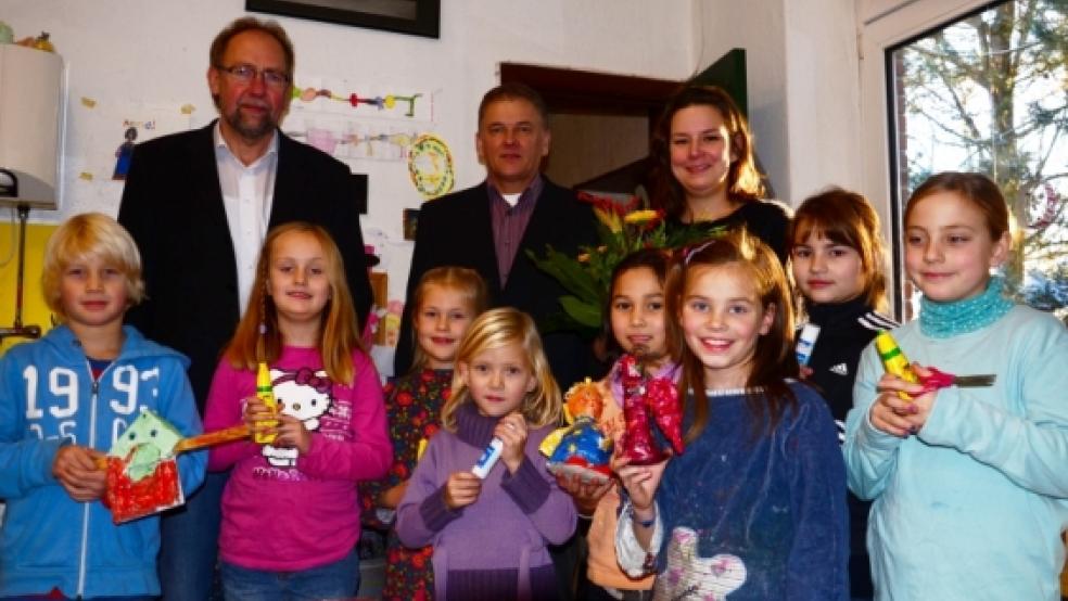 Einen Strauß Blumen überreichten Bürgermeister Gerald Sap (Mitte) und Fachbereichsleiter Harm Watermülder von der Gemeinde Bunde an »KUMU«-Leiterin Resa Rieken. Die Kunstschüler zeigen ihr Werkzeug und einige Kunstwerke.  © Wübbena