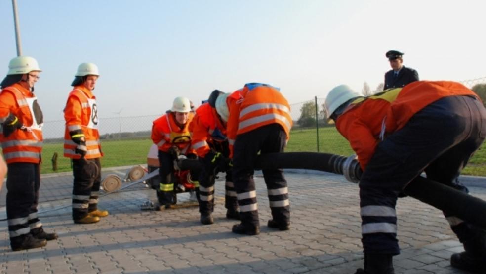 Der vier Mann starke »Wassertrupp« der Feuerwehr Weener legt die Schlauchverbindung zwischen dem »offenen Wasser« und der Tragkraftspritze. Gruppenführerin Christina Schulte (links) und Maschinist Mirco Cordes warten auf den nächsten »Angriffsschritt« © Kuper