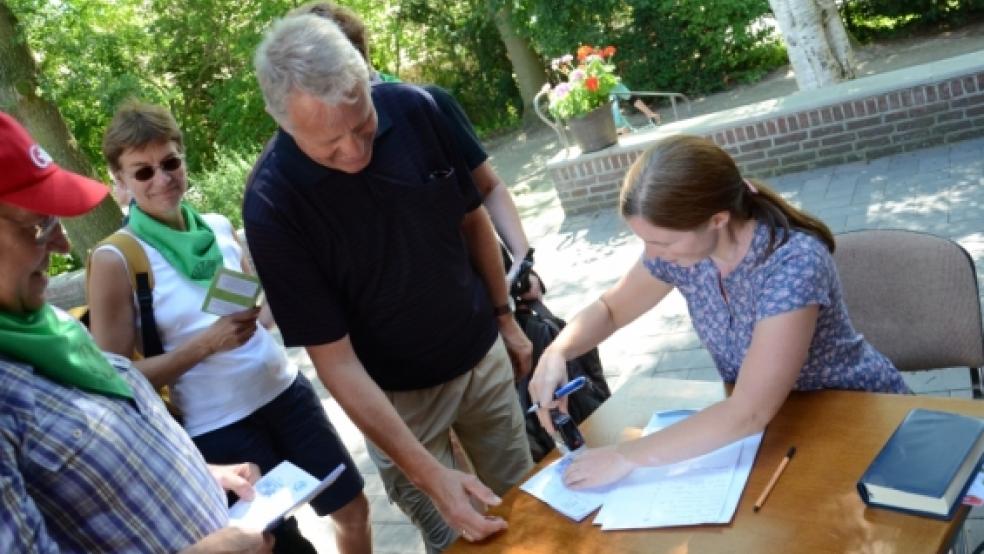 Carmen Kramer (Kirchengemeinde Hollen) stempelte die Pässe der 43 Pilger, die am Sonntag in Bunde einkehrten. © Wübbena