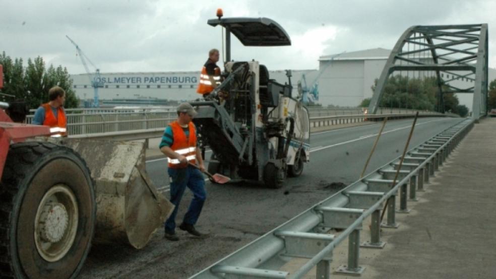 Arbeiter der Firma Peters sind seit gestern Vormittag mit der Sanierung der Asphaltdecke auf der Halter Brücke beschäftigt. Der Verkehr aus dem Rheiderland wird am Kreisel in Stapelmoor über Rhede umgeleitet (kleines Bild). © Szyska