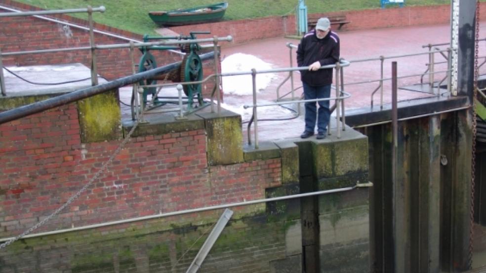 Obersielrichter Hinrich Geerdes blickt mit Sorge auf die marode Flügelwand. Das Siel am Ditzumer Hafen muss für 140.000 Euro saniert werden.  © Foto: Boelmann