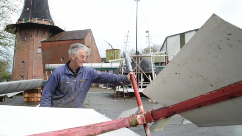Freizeitmüller Dieter Hunken nimmt die Windrose der Bunder Mühle in Augenschein. Sie befindet sich, ebenso wie die Kappe, am Boden und wartet auf die Reparatur. © Hanken