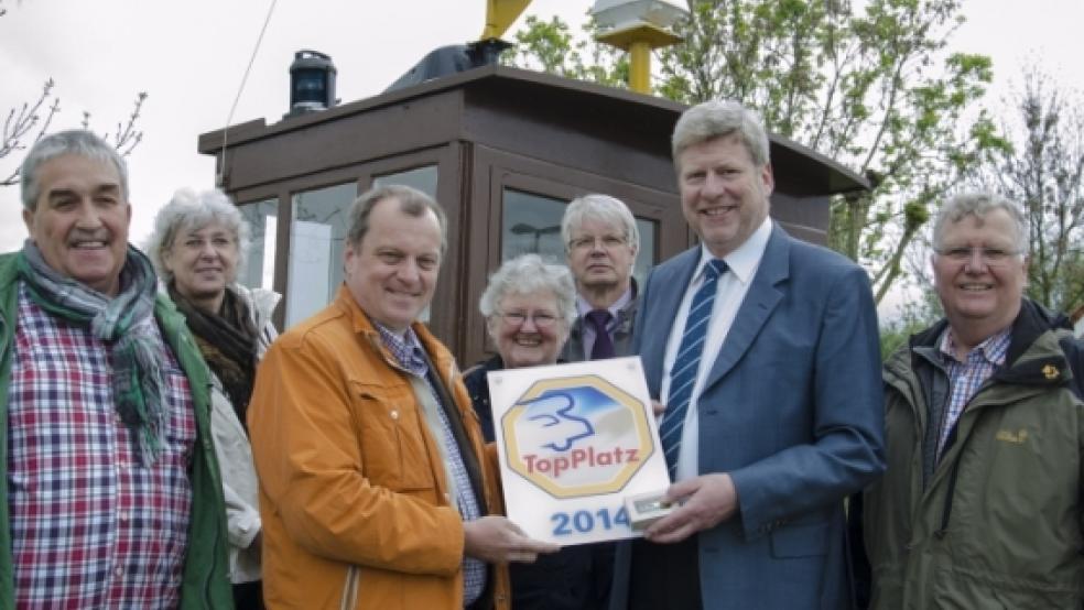 Eine Plakette für den Ditzumer Stellplatz überreichte Jürgen Dieckert (gelbe Jacke), Herausgeber des »TopPlatz«-Reiseführers, Bürgermeister Johann Tempel am Donnerstag. Erfreut über die Auszeichnung sind ebenfalls (von links) Manfred Klinkenborg (Wohnmobil-Stellplatzberater Landkreis Leer), Silke Gärtner (Tourist-Info Leiterin Detern), Annegret Bommelmann (1. Vorsitzende Verkehrsverein Ems-Dollart), Dieter Voß (Bürgermeister Jümme) und Luitpold Handwerker (Geschäftsführer VVED). © Foto: Wübbena
