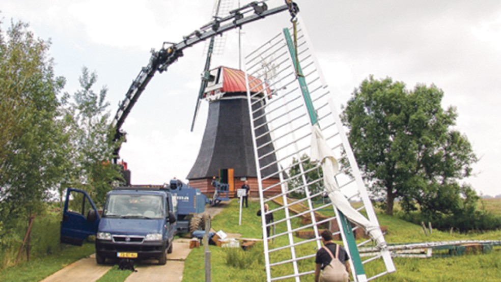 Die Flügel der Wasserschöpfmühle landen am Boden neben dem Erdholländer. Mitarbeiter der Firma Molema bereiten hier die Reparatur der Kappe vor. © Foto: Boelmann