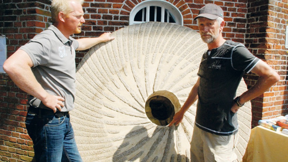 Fachsimpelei in Jemgum am alten, 1800 Kilogramm schweren Mühlenstein zwischen dem Mühlenwart und dem Vorsitzenden des Mühlenvereins, Stefan Sinning (links) und Harmannus Knevel. Letzterer hatte den neuen Mühlenstein aus den Niederlanden nach Jemgum transportiert.  © 