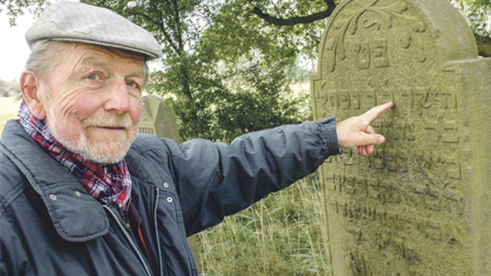 Auf dem Grabstein, auf den Fritz Wessels zeigt, stehen neben der hebräischen Inschrift die französischen Worte »a la memoire des Cerf« (»Zum Gedächtnis an Hirsch«). Der Tote dürfte wohl in der Franzosenzeit vor 1813 beigesetzt worden sein, als das Rheiderland zum Departement Winschoten gehörte und das Rathaus in Weener den Namen »Mairie Weener« trug. Die letzte Beerdigung auf dem Friedhof in Smarlingen hat 1849 stattgefunden. © 