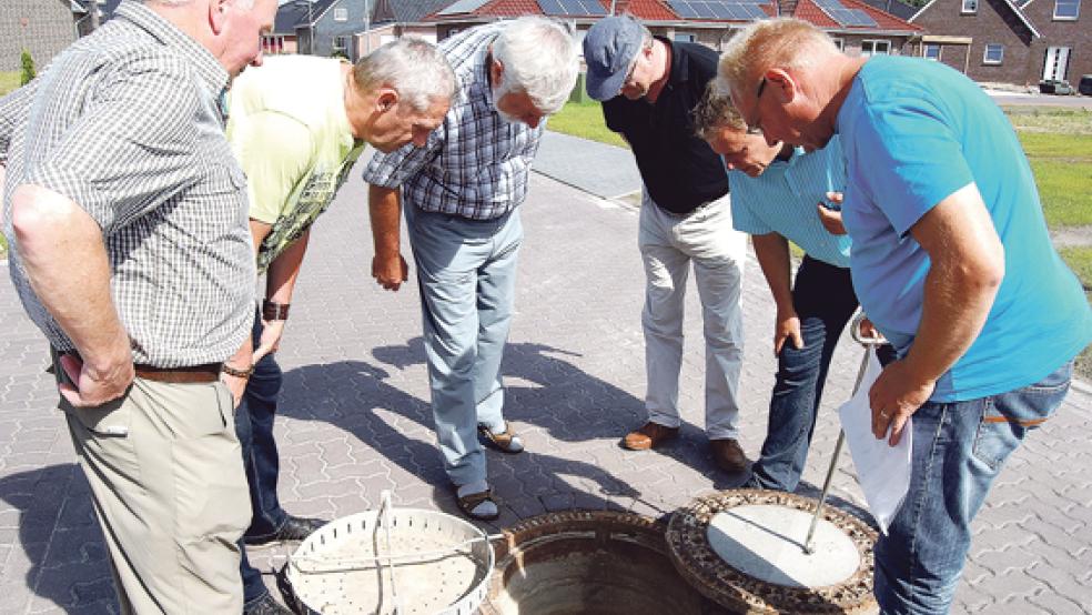 Blick in die »Unterwelt«: Ortsvorsteher Wilhelm Ostendorp, Wilfried Schütte, Georg Huisinga, Bauamtsleiter Manfred de Buhr, Bürgermeister Gerald Sap und Georg Frieling (von links) bei der Kontrolle eines Kanalschachtes auf dem Berumer Ring. © Foto: Hoegen