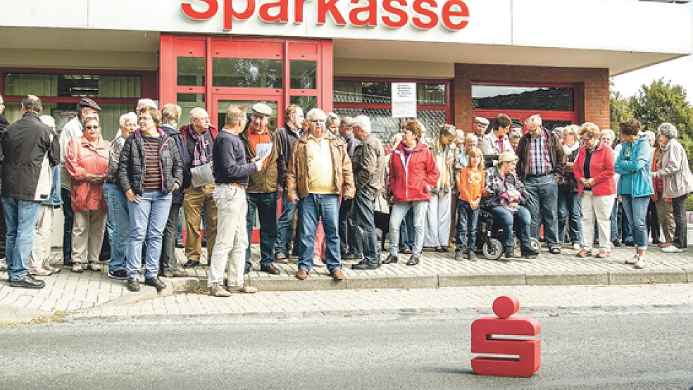 Über 50 Bürger versammelten sich gestern vor der Sparkassenfiliale in Ditzumerverlaat, um gegen die geplanten Schließungen zu demonstrieren. © Fotos: de Winter