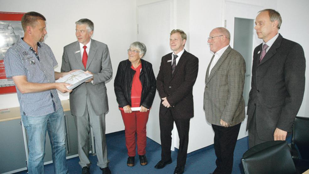 Ein geschnürtes Paket mit rund 1400 Protest-Unterschriften überreichte Johann Robbe vom SPD-Ortsverein Ditzum gestern Abend an Sparkassen-Chef Heinz Feldmann (von links). Robbe wurde von der Bingumer Ortsvorsteherin Bärbel Bieder (Mitte) und dem Pogumer Helmut Seidemann (Zweiter von rechts) begleitet. Die Sparkasse vertraten zudem Vorstandsmitglied Carsten Rinne (rechts) und der stellvertretende Pressesprecher Reinhard de Witt. © Foto: Szyska