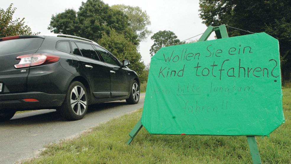 In Bingumgaste greifen Anwohner zur Selbsthilfe. Auf Schildern fordern sie Autofahrer, die dem Stau auf der B 436 ausweichen wollen, mit drastischen Formulierungen zur Vorsicht auf. Sie haben auch Dreiräder und Kinderspielzeug am Straßenrand aufgestellt, damit langsamer gefahren wird. © Foto: Szyska