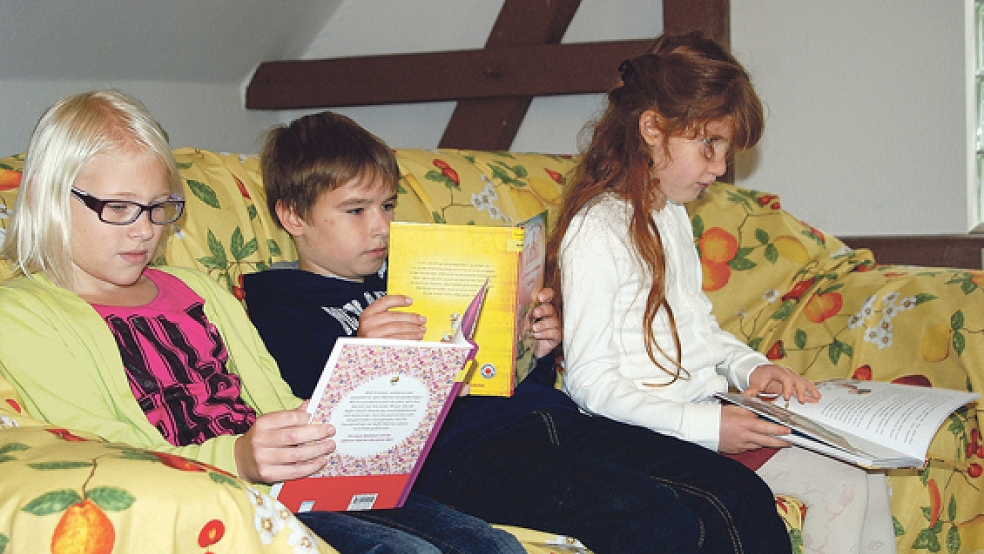 Alina, Tom und Sara vertiefen sich auf dem gemütlichen Sofa in interessante Bücher. © Fotos: Hoegen