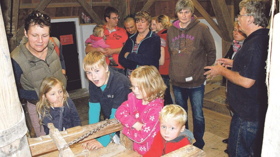 Manfred Gräbe erklärt bei der dritten Führung des Tages Besuchern aus Holthusen, Papenburg und Weener auf der 4. Ebene der Mühle das Mahlwerk und den Mahlvorgang. © Fotos: Kuper