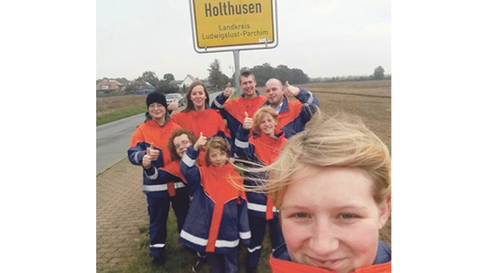 Vor dem Ortsschild »Holthusen Landkreis Ludwigslust-Parchim« stehen einige Mitglieder der Jugendfeuerwehr Holthusen mit Jugendwartin Mareike Riemeyer (vorne).  © Foto: privat