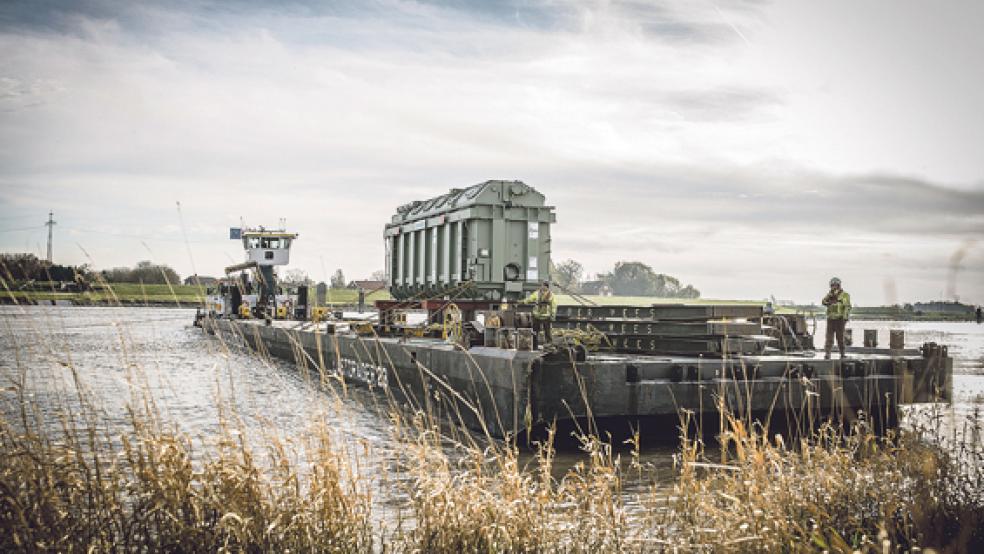 Geschafft! Der Tennet-Trafo erreicht am Sonntagmittag auf einem Schiffsponton die Verladerampe in Bingum. © Foto: Klemmer