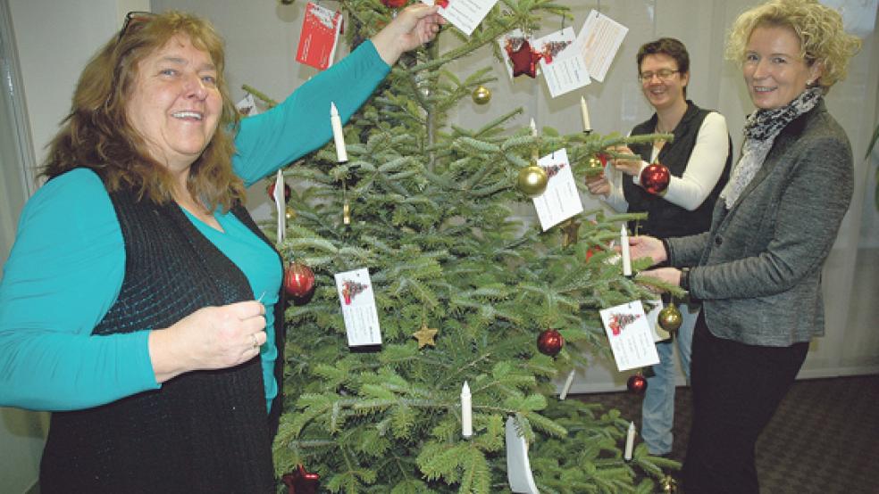 Den Weihnachtsbaum mit den Karten, auf denen die Wünsche der Kinder stehen, präsentierten gestern in der Sparkasse in Jemgum die Initiatorinnen der Aktion »Weihnachten für Kinder«: Emmi Gronewold, Nicole Zimmer und Kerstin Krebs (von links). © Foto: Szyska