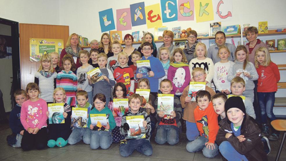 Die Schülerinnen und Schüler in Stapelmoor freuen sich über die Buchspende des Fördervereins. Hinten von links: Anita Timmer von der Bücherei der Grundschule, Susanne Fockens, Gabi Gödecke, Bettina Kubiak, Heike Hanisch, Elke Sanders, Sheila und Stefan Kuper sowie Hanne Yzer. © Foto: Hoegen