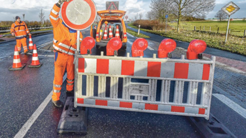 Mitarbeiter der Straßenmeisterei Leer stellten am Samstagmittag die Sperrbaken auf beiden Seiten der Emsbrücke auf. Für den Kfz-Verkehr sowie Radfahrer und Fußgänger war die Brücke mehr als zehn Stunden lang nicht passierbar. © Foto: Bruins