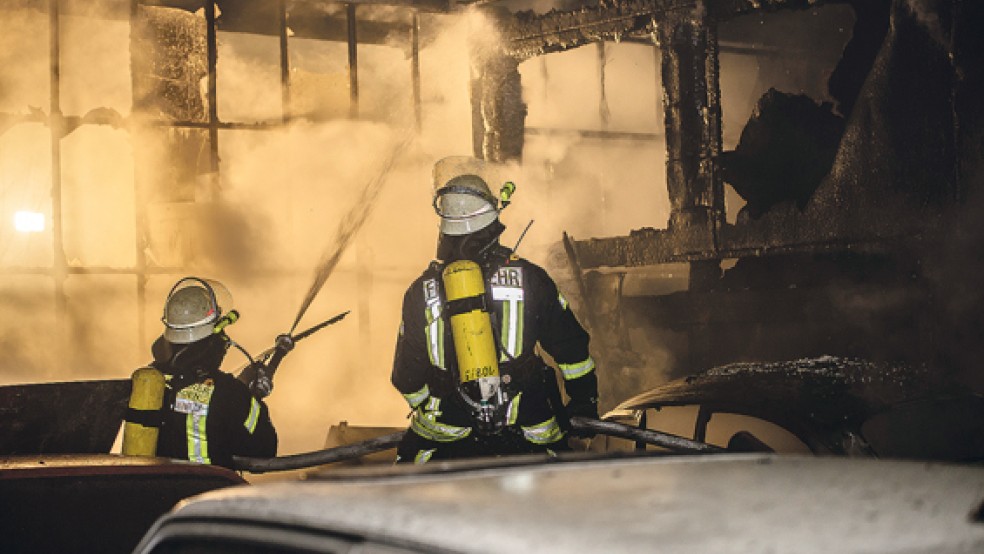 Unter Atemschutz nahmen Feuerwehrleute aus Bunde und Wymeer den Kampf gegen die Flammen in der Lagerhalle an der Neuschanzer Straße auf. © Foto: Klemmer