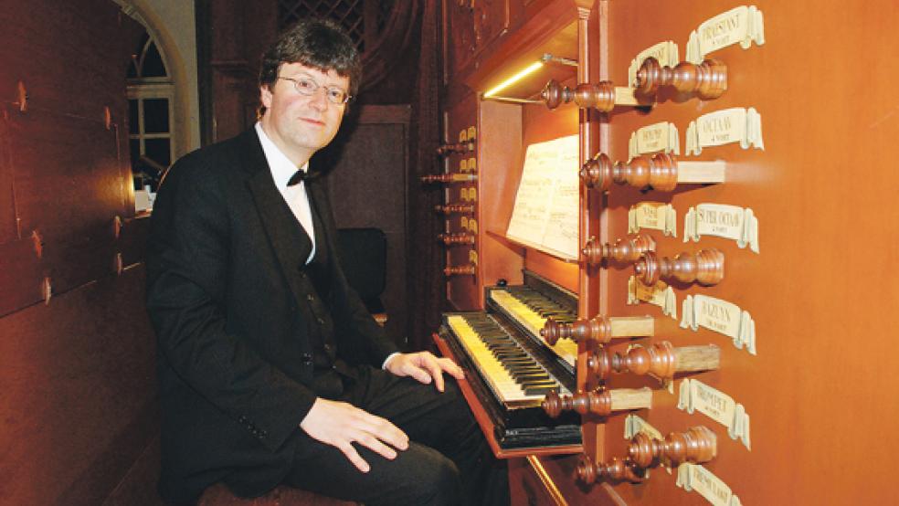 Winfried Dahlke an der zweimanualigen Klaviatur der Schnitger-Orgel in Weeners Georgskirche, wo er am Sonntag sein 9. Neujahrskonzert gab. Rechts auf dem Foto zwölf der insgesamt 29 hölzernen Registerzüge des über 300 Jahre alten Instrumentes.  © Foto: Kuper