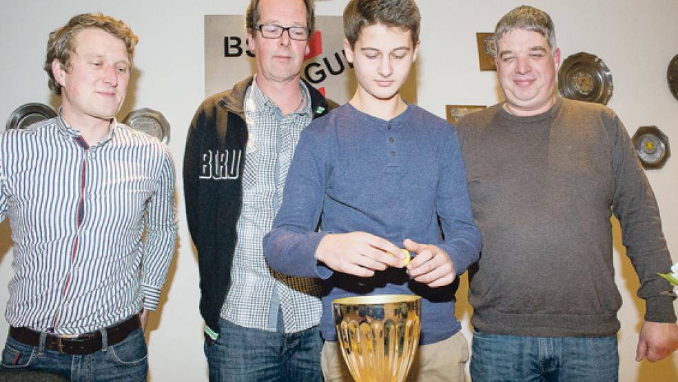 Der 13-jährige Yannick Geib zog im Bingumer Vereinsheim die Vorrundengruppen. Jan Ubbens, Hartmut Roelfs und Carsten Kempen vom BSV beobachten ihn gespannt. © Foto: Mentrup