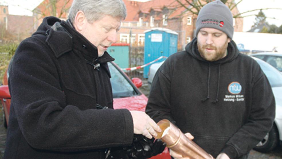 In das Kupferrohr, das Anlagenmechaniker Markus Wilken aus Jemgum (rechts) mitgebracht hatte, steckte Bürgermeister Johann Tempel auch eine aktuelle RZ-Ausgabe. © Foto: Szyska