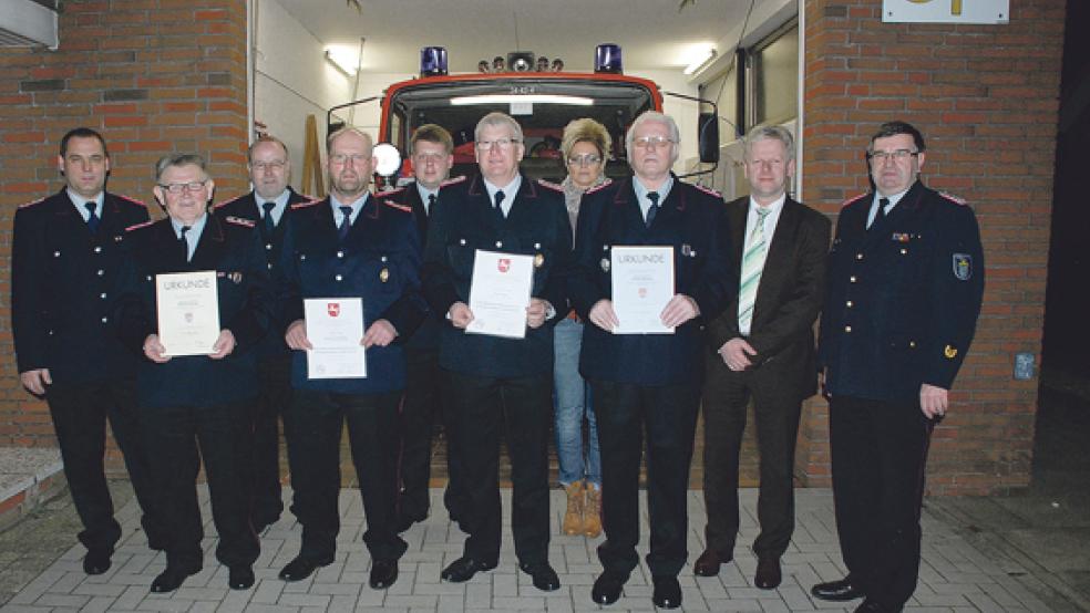 Vier Ehrungen langjähriger Mitglieder: (vorne, von links mit Urkunde) Wilhelm Markus (50 Jahre), Hermann Woldenga (40 Jahre), Enno Nagel (40 Jahre) und Willem Molanus (40 Jahre); dahinter (von links) Stadtbrandmeister Jörg Fisser, sein Stellvertreter Gerhard Kuper, Ortsbrandmeister Okko Duismann, Christiane Dorenbos (Ordnungsamt Stadt Weener), Bürgermeister Ludwig Sonnenberg und Kreisbrandmeister Theodor de Freese.  © 