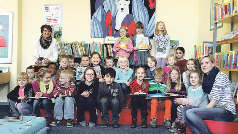 Die Schüler der Grundschule Weener und der Pestalozzischule besuchen mit Angelika Bödeker (rechts) und Christina Olliges (rechts) die Stadtbücherei in Weener.  © Foto: Garrels