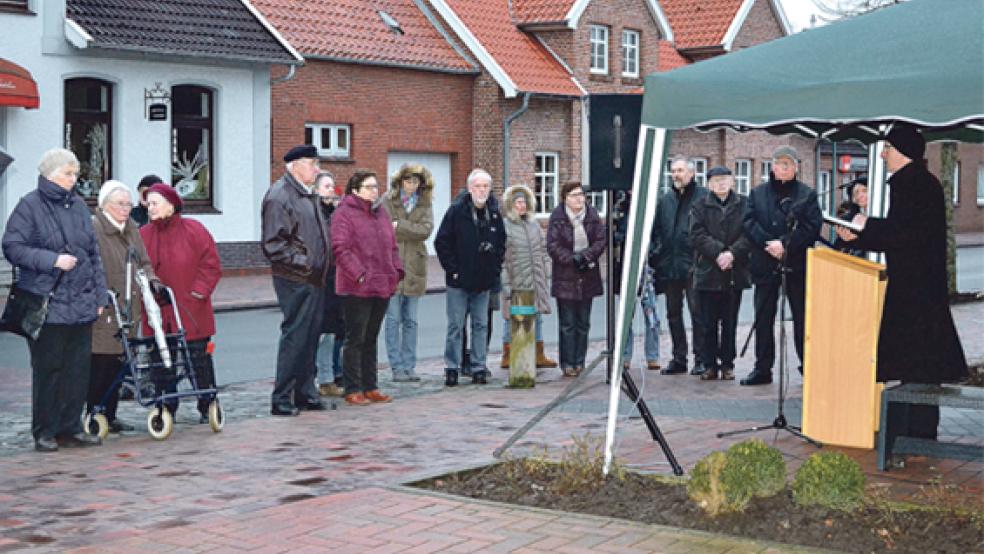 Bunder Bürger trotzten dem Regen und eisigem Wind und gedachten gemeinsam mit Pastor Michael Groothues, Bürgermeister Gerald Sap und Ratsvorsitzender Theus Graalmann den ermordeten Bunder Jüdinnen und Juden. Tariq Zaanan, Astrid Fokken und Nadim Abd El Hay (kleines Bild von links), Schüler der Oberschule Bunde, verlasen die 77 Namen, die auf dem Mahnmal am Kirchring verewigt sind. © Fotos: Hülsebus