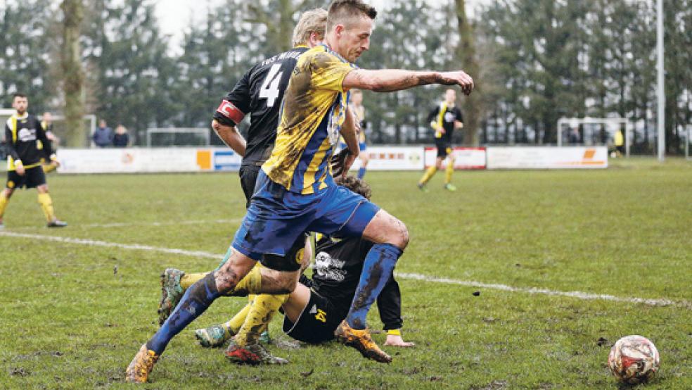 Zur Schlammschlacht wurde das Kampfspiel zwischen dem TuS Weener und dem TuS Middels. Hier duellieren sich Martin Meyer und Christian Janssen um den Ball. © Foto: Schulte