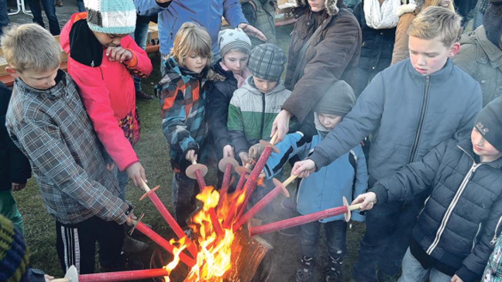 Kinder in Ditzumerverlaat zünden ihre Fackeln an, mit denen das Osterfeuer später entfacht werden soll.  © Fotos: Hülsebus