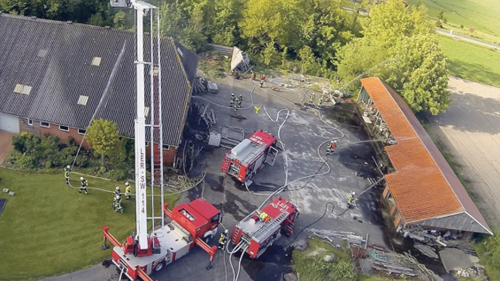 Ein Blick von oben auf die Übung der Feuerwehr auf einem Bauernhof in Weenermoor. Gerrit Yzer (kleines Bild) wurde für seine langjährige Tätigkeit als Sicherheitsbeauftragter ausgezeichnet. © Fotos: Rand/ Feuerwehr