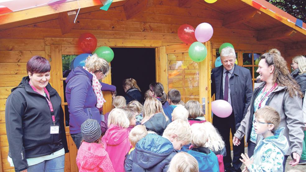 Sonja Finke als Vorsitzende des Fördervereins (rechts) freut sich, dass die Kinder ihr neues Blockhaus gleich in Besitz nehmen. Neben ihr an der Tür der Hütte Bürgermeister Ludwig Sonnenberg. © Foto: Hoegen