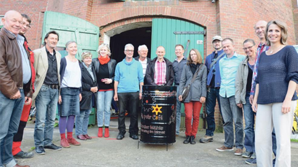 Die Leuchttonne aus der Mühlen-Werkstatt von Dieter Hunken (Mitte) weist künftig Besuchern und Kunden den Weg zum Repair Café Bunde. An jedem ersten Samstag im Monat sollen in der Mühle ehrenamtlich Reparaturen angeboten werden. Das Foto zeigt die Helfer mit den Initiatoren Viviana (rechts) und Hildebrand van der Spa (7. von rechts). © Foto: Hanken