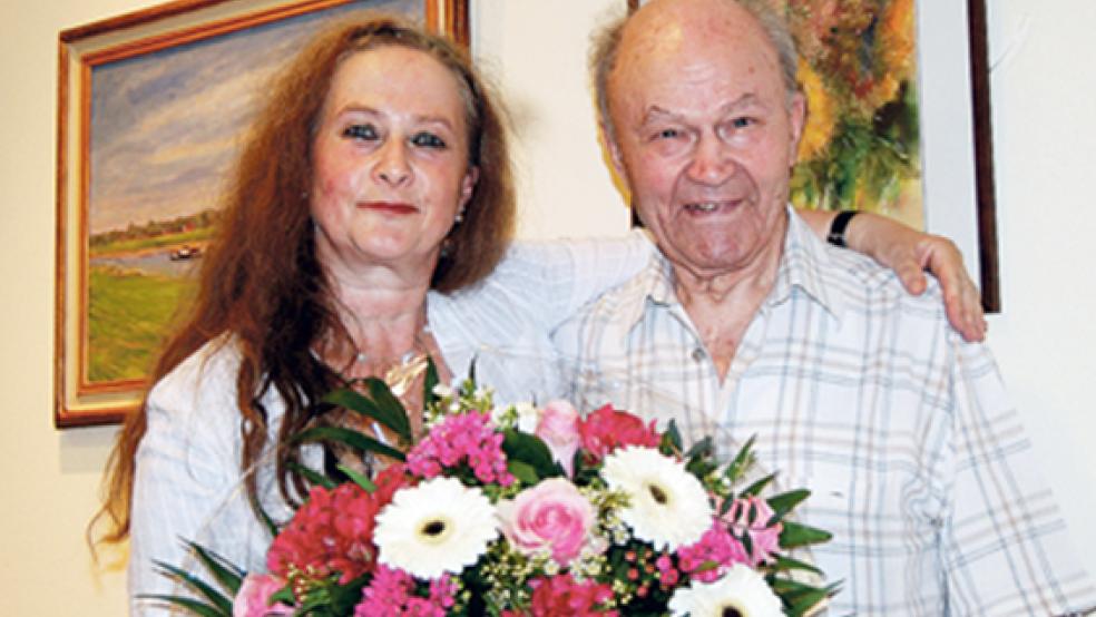 Blumen und ein Blumenbild: Künstler Dr. Volker Bornemann und seine Tochter Regina, die bei der Vernissage in das Werk ihres Vaters eine Einführung gab. © Foto: Hoegen