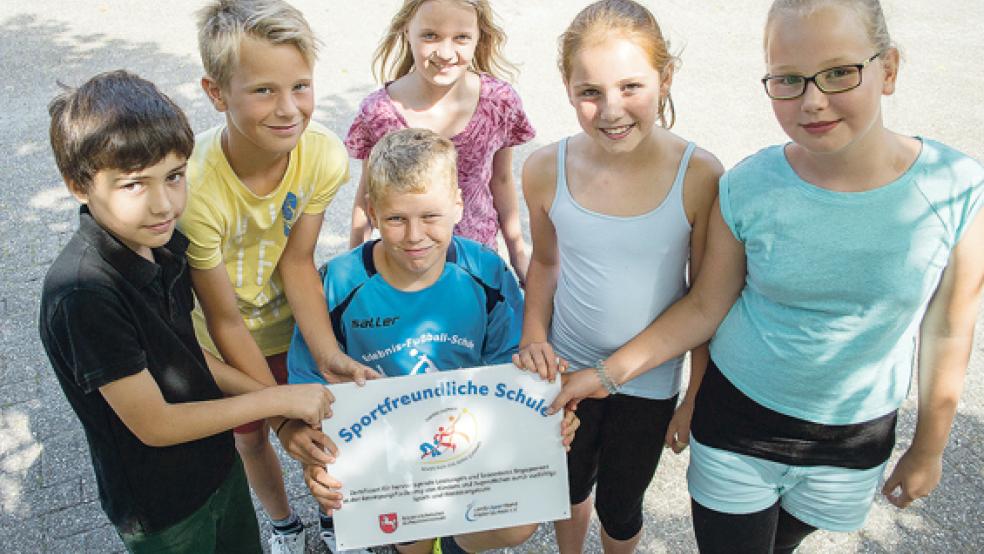 Das ist der Beweis: Jeremy, Steffen, Kevin, Jasmin, Jula, und Eleah zeigen das Schild, das die Grundschule Möhlenwarf als sportfreundliche Schule ausweist. Es wird einen gebührenden Platz erhalten.  © Fotos: Mentrup