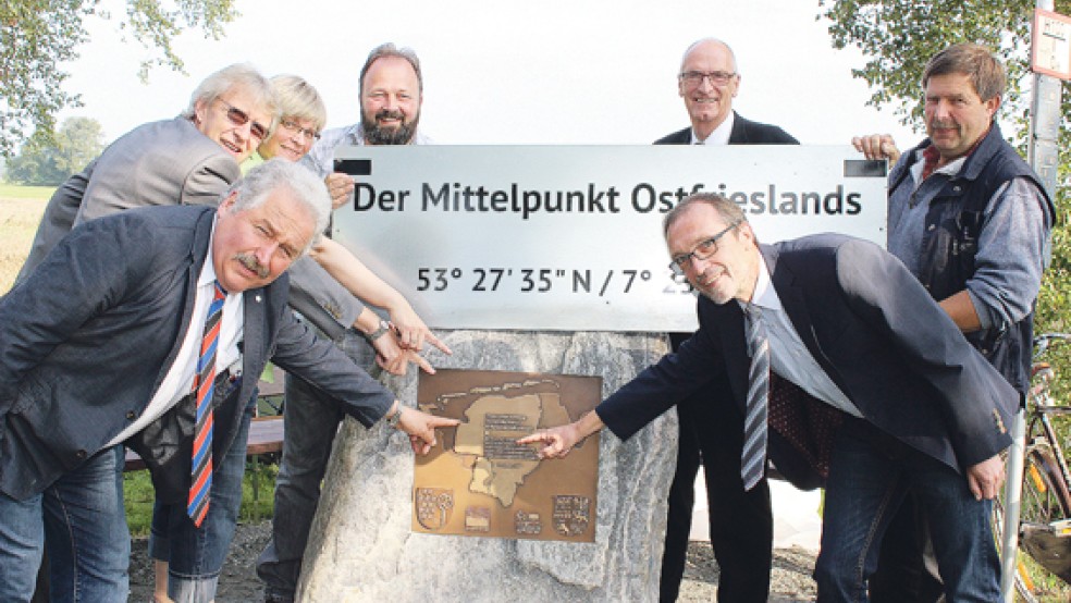 Ein Gedenkstein markiert den Mittelpunkt Ostfrieslands in Westerende-Holzloog. Er wurde enthüllt von (von links) Landschaftspräsident Rico Mecklenburg, Hinrich Tjaden (Firma Matthäi), der Touristik-Fachfrau Gerda Hinrichs, Ortsbürgermeister Heino de Vries, dem Ihlower Bürgermeister Johann Börgmann, Martin Hepp (Entwicklungs- und Dienstleistungsgesellschaft Ihlow, vorne) und Bauhofleiter Focko Oltmanns. © Foto: Meyer