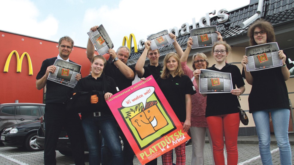 Die Organisatoren der Plattdeutsch-Aktion bei McDonalds mit den entworfenen Tablettauf­lagen. © Foto: Schaller