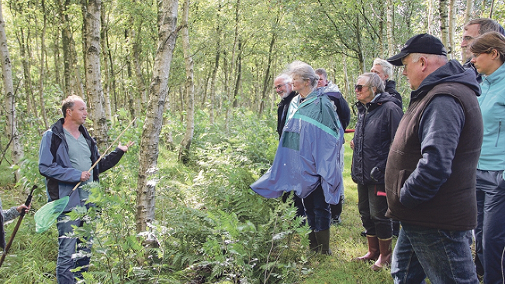»Moorvogt« Detlef Kolthoff (links) klärt Naturfreunde über die Pflanzen- und Tierwelt sowie über die Entstehung des Hochmoores in Wymeer auf. © Fotos: Flockenhagen