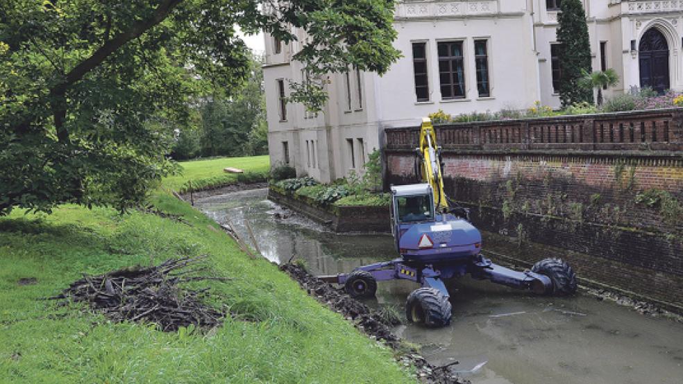 Der Spezialbagger steht derzeit ungenutzt im Schlossgraben der Evenburg. Nachdem bei Böschungsarbeiten geringe Mengen von Gewehrmunition gefunden wurden, soll der Bereich zunächst von einer Spezialfirma untersucht werden. © Foto: Wolters