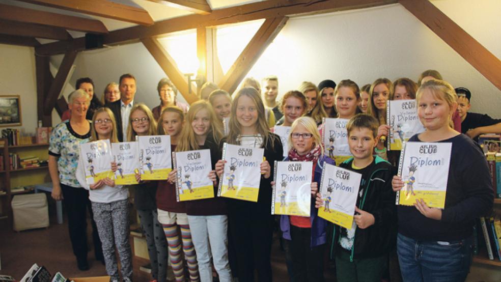 Bei der Abschlussveranstaltung: Die Kinder des Julius-Clubs mit ihren Diplomen, das Team der Stadtbibliothek mit der Leiterin Susanne Fockens (links) und Ralf Haverkamp von der VGH-Regiondirektion aus Emden.  © Foto: Flockenhagen