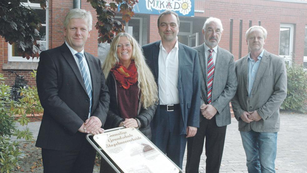 An einem neuen Schild vor dem Heilpädagogischen Kindergarten, das an die Geschichte der Heidjer Dorfschule erinnert: Bürgermeister Ludwig Sonnenberg, Lebenshilfe-Abteilungsleiterin Katja Roth, Lebenshilfe-Bereichsleiter Heiko Höfelmann, Lebenshilfe-Geschäftsführer Ralf Schulz und Architekt Bernd Norrenbrock (von links). © Foto: Szyska